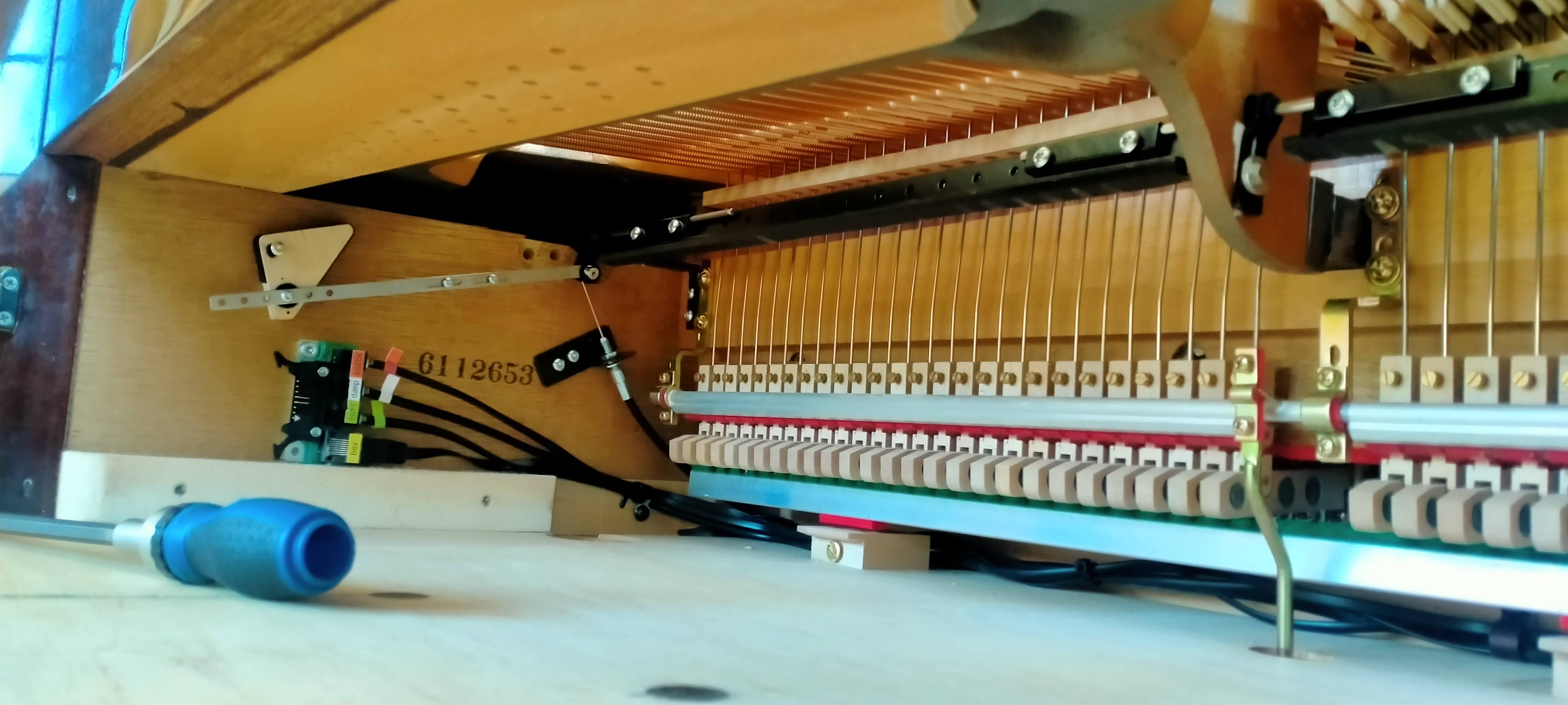 Interior de piano vertical con sistema electrónico instalado