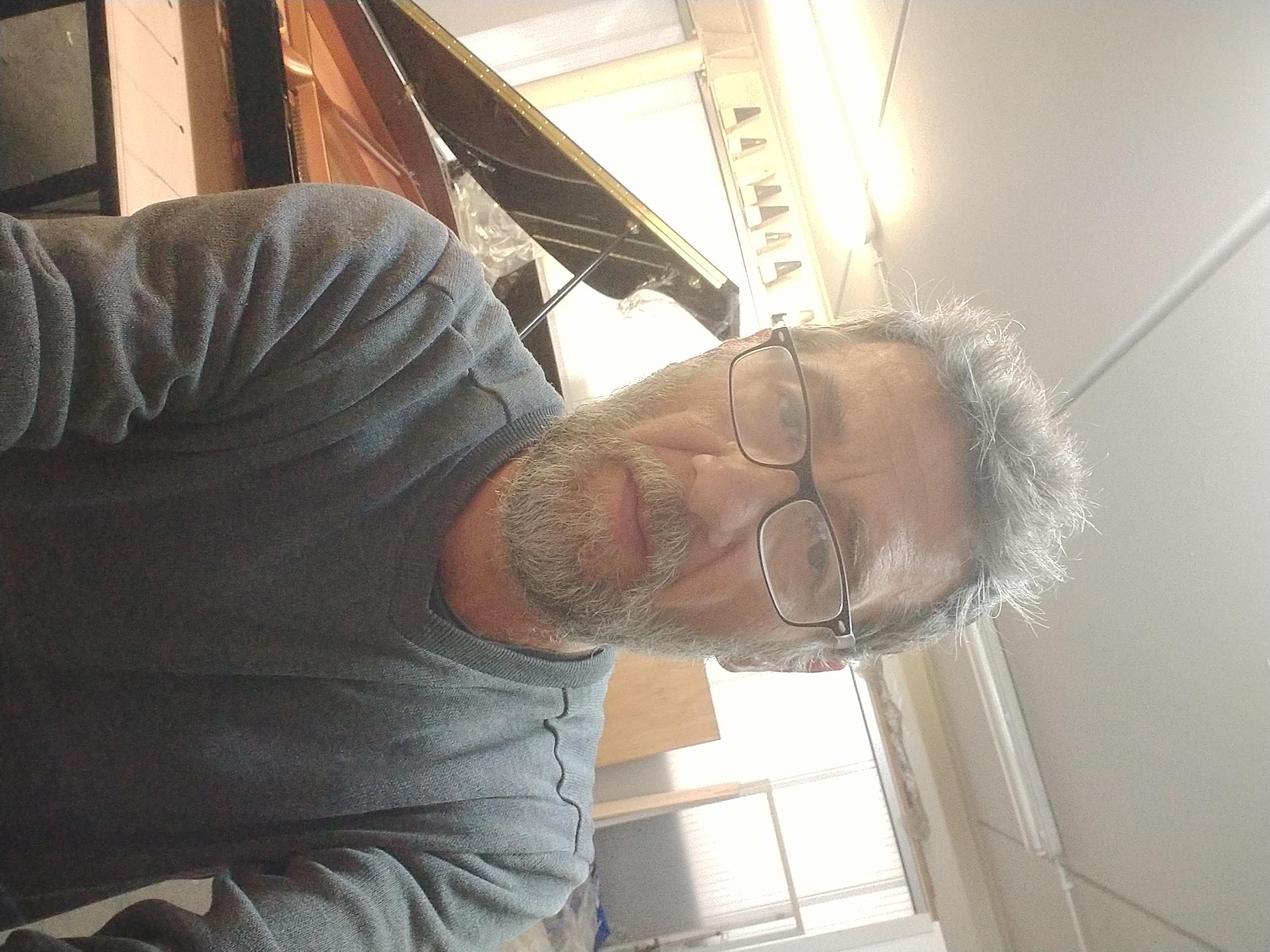 Técnico afinador junto a piano de cola en trabajo