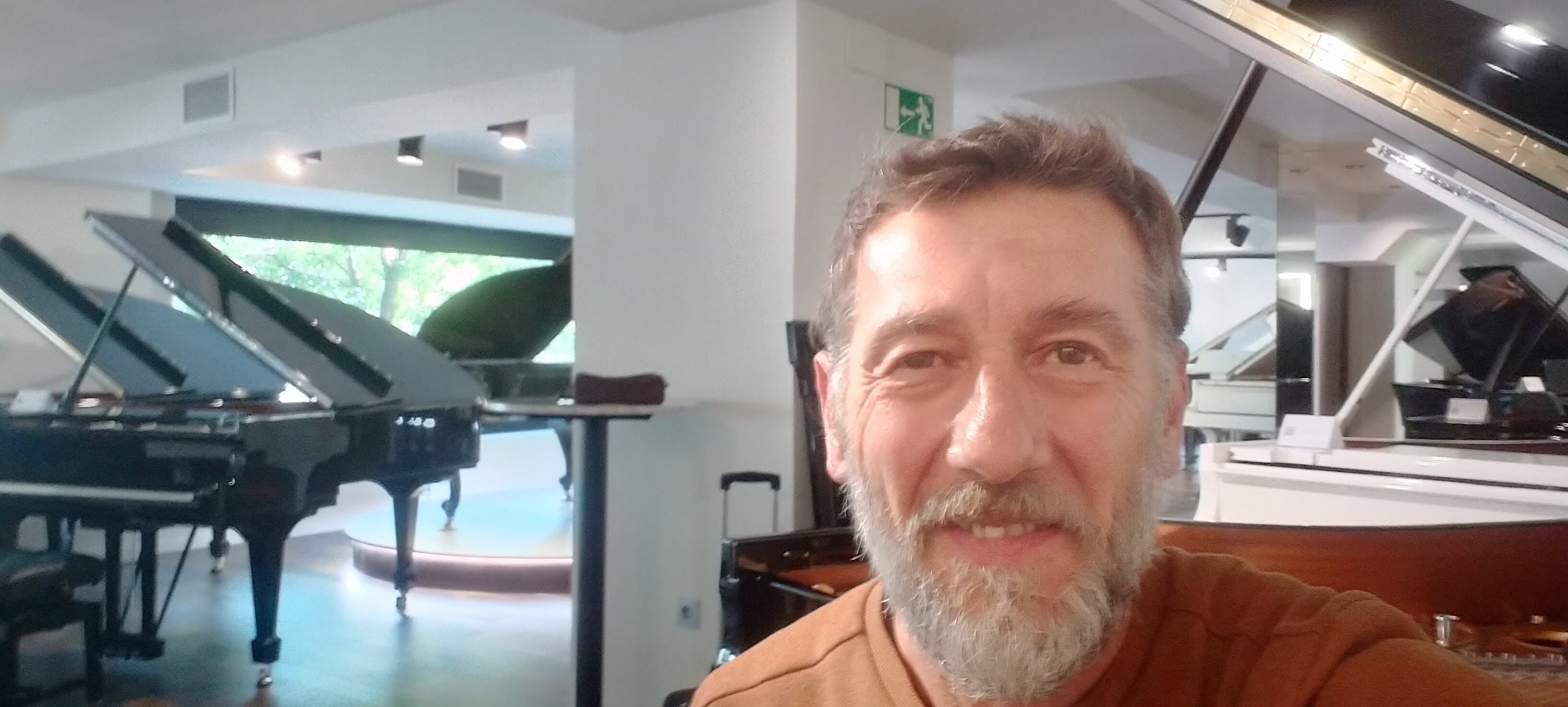 Gonzalo en showroom con varios pianos de cola