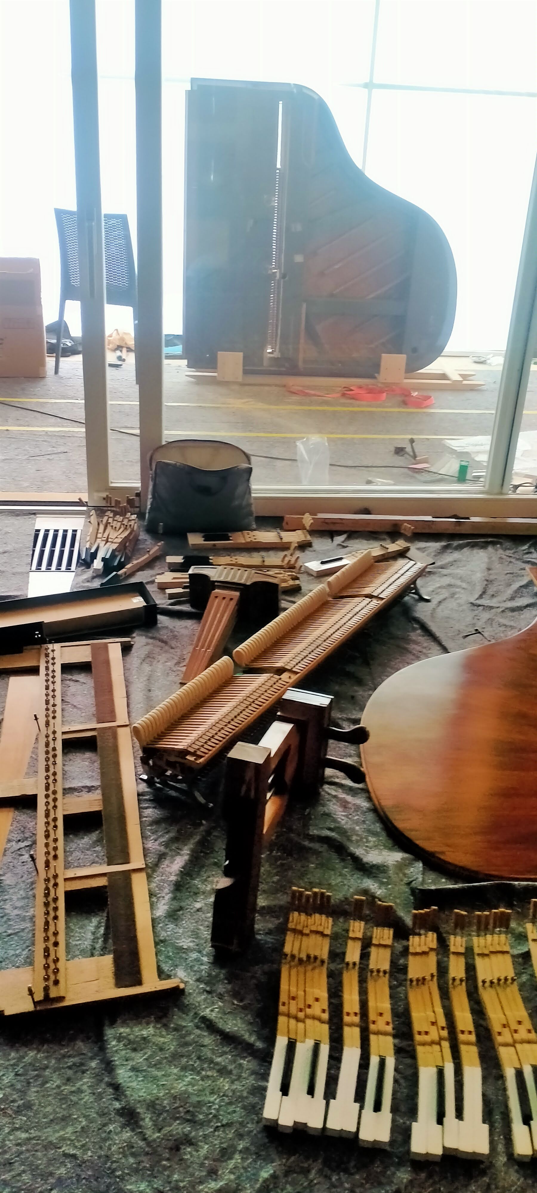 Piezas desmontadas de piano de cola durante restauración completa